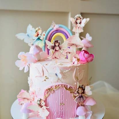 Pastel fairy cake with a sugar rainbow, fairies and a pink door